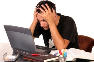 laptop előtt ülő stresszes férfi
